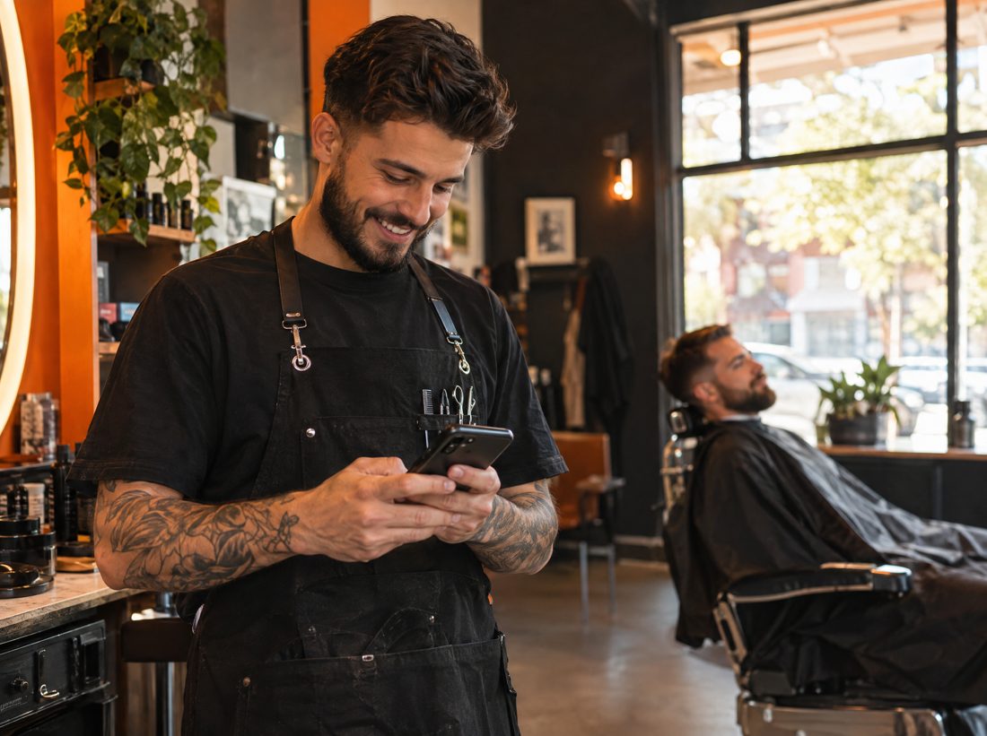 Barber sending the link from his phone in the shop